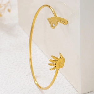 Adjustable golden stainless steel cuff bracelet with baby feet and palm zircon accents