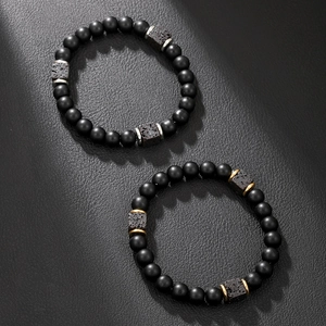 Detail of matte black lava stone bead necklaces with gold and silver square accents