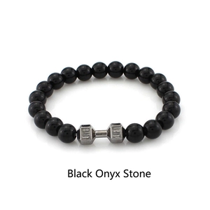 Détail du bracelet de fitness en perles d'onyx noir avec un charm haltère en argent