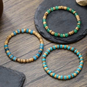 Tre bracciali elastici bohémien con pietre naturali e perline di legno su fondo scuro