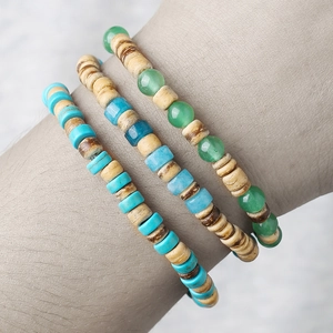 Dettaglio di braccialetti in pietra naturale e perline di legno con texture bohémien