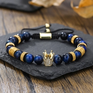 Dettaglio del bracciale con occhio di tigre blu, corona dorata, zirconi e cordino regolabile