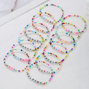 Pulseras bohemias de cuentas coloridas con letras sobre fondo blanco con textura