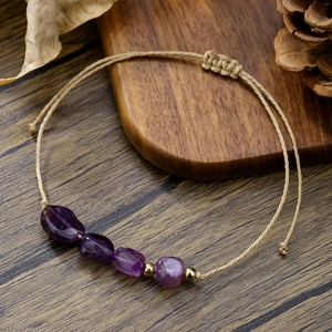 Dettaglio macro del bracciale in ametista intrecciato a mano con pietre naturali e cordino