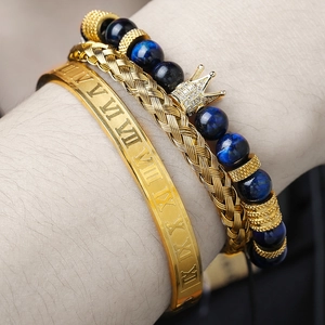 Dettaglio del set di braccialetti hip hop con polsino romano e ciondolo a corona blu