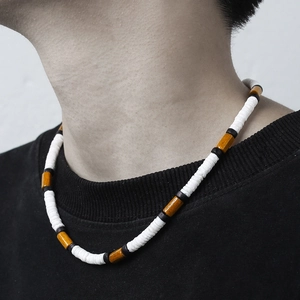 Mens surfer necklace with white heishi beads, coconut shell and wood beads on black t-shirt