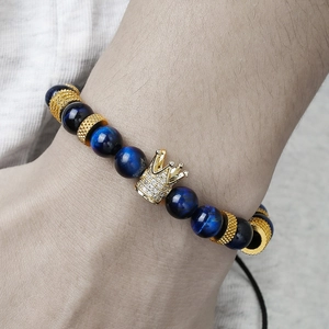 Dettaglio del bracciale in occhio di tigre blu con corona dorata e zirconi cubici incastonati