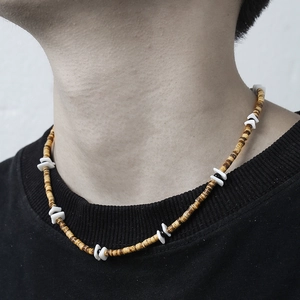 Bohemian seashell and wood bead necklace with stainless steel clasp for men on black shirt