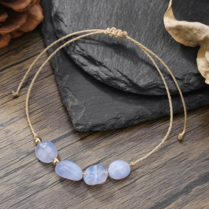 Dettaglio del bracciale intrecciato a mano con pietre naturali blu e perle dorate