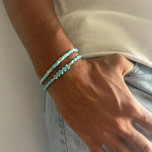 Detail van de bohemien turquoise kralen armbandenset met hart en zilveren accenten om pols