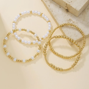 Dettaglio del set di braccialetti con perle di conchiglia e perline metalliche dorate
