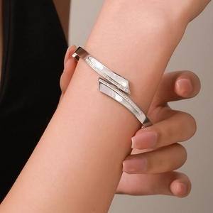 Bracelet en acier titane argenté au design croisé serti de nacre et de zircons fins