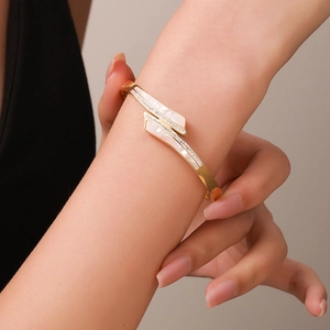 Bracelet croisé en acier titane doré avec incrustations en nacre et zircons