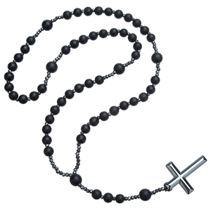 Close-up of religious cross pendant with matte black beads and hematite stones necklace