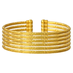 Gedetailleerde macro van zes vergulde C-vormige armbanden met fijne gravuretextuur