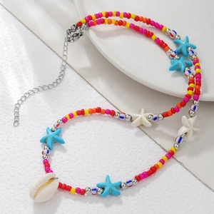 Detail of colorful bohemian beaded necklace with natural shell pendant and star accents