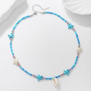 Close-up of Bohemian beaded necklace with blue sea stars and a natural white shell pendant