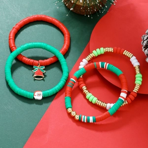 Detailed view of Christmas snowman and Santa Claus charms on four colorful Heishi bracelets