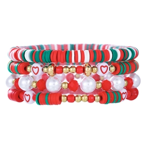 Close-up of four-piece layered Christmas bracelets with red and green Heishi beads