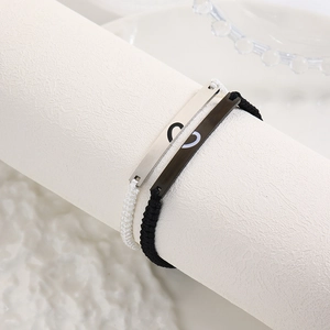 Macro detail of adjustable woven cord couple bracelets with heart-shaped metal plates