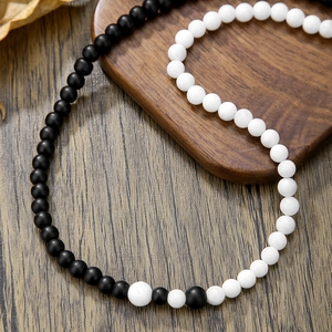 Collar Yin Yang con cuentas de ágata negra y porcelana blanca en bandeja de madera