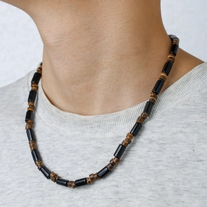 Detail of bohemian surf necklace with black cylindrical beads and wooden brown disc beads