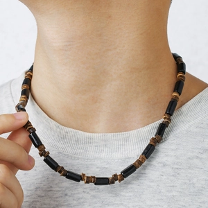Detail of bohemian surf necklace with black beads and dark brown coconut wood spacers