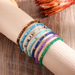 Handmade tiger eye and amethyst beaded bracelets on a wooden display stand for women