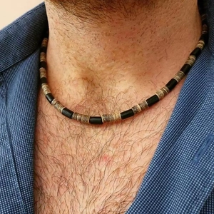 Collier pour hommes en perles de bois de coco noir et marron porté sur une chemise à carreaux