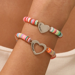 Dettaglio di braccialetti in perline heishi colorate con ciondoli a cuore Madre e Figlia