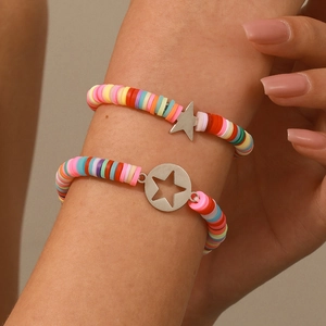 Dettaglio di due braccialetti in perline Heishi colorate con ciondoli a stella in argento e luna