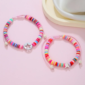 Dettaglio di braccialetti in argilla colorata con ciondoli a stella in metallo
