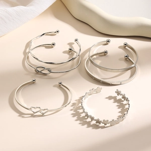 Detail van een 5-delige zilveren armbandenset met knoop, hart en LOVE-gravures stijl