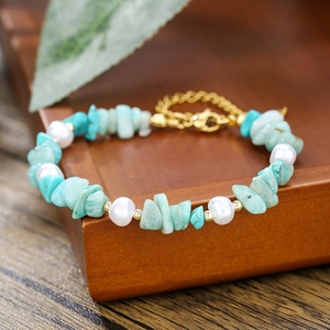 Detalle macro de pulsera de piedra natural y perlas con cierre dorado ajustable