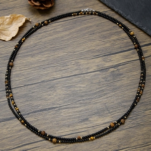 Elastische kralenarmband met tijgeroog stenen, zwarte onyx en gouden metalen accenten