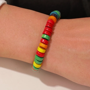 Primer plano de una pulsera elástica de cuentas de madera coloridas en la muñeca