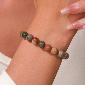 Dettaglio di perline in pietra sfaccettata colorata di un bracciale loto yoga al polso