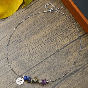 Macro shot of Aquarius constellation necklace with natural stones on a wood surface