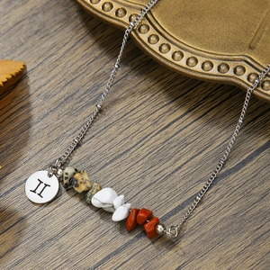 Detail of Gemini constellation necklace with natural crushed stones and silver pendant