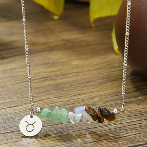 Close-up of Taurus zodiac necklace with colorful natural stone chips and silver pendant