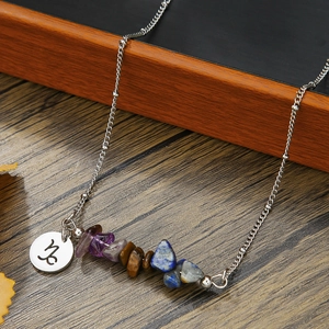 Macro detail of Capricorn zodiac pendant with natural crushed stone beads on silver chain