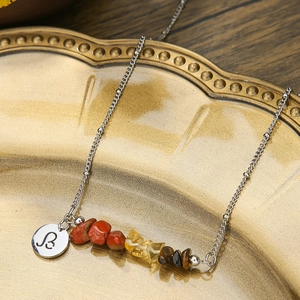 Close-up of a stainless steel necklace with colorful crushed stones and Leo zodiac pendant