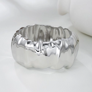 Macro detail of the silver-plated wide band ring with liquid-like wavy metal textures