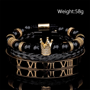 Dettaglio del bracciale da uomo in onice nera con corona e bracciale rigido romano dorato