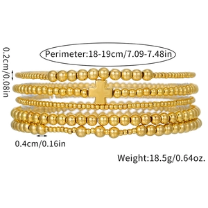 Detail of stacked gold beaded bracelets with cross pendant and precise measurement specs