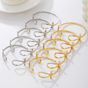 Set of 6 gold and silver Egyptian Ankh cross open bangles in minimalist jewelry display