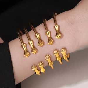 Five-piece set of gold fist-shaped open bracelets in hip-hop punk style worn on wrist