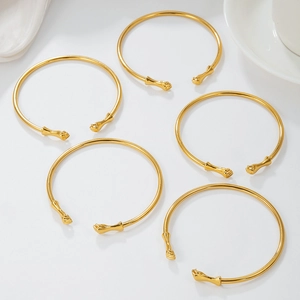 Set of 5 golden punk fist open cuffs made of polished metal in minimalist style