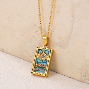 Macro shot of gold tarot sun pendant with colorful gemstones and engraved details