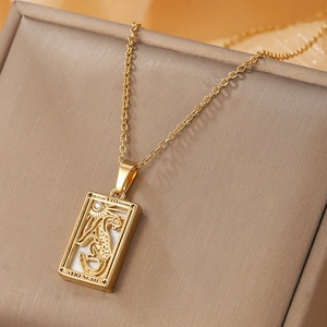 Detail of gold stainless steel Tarot Strength pendant with embossed lion and zircon